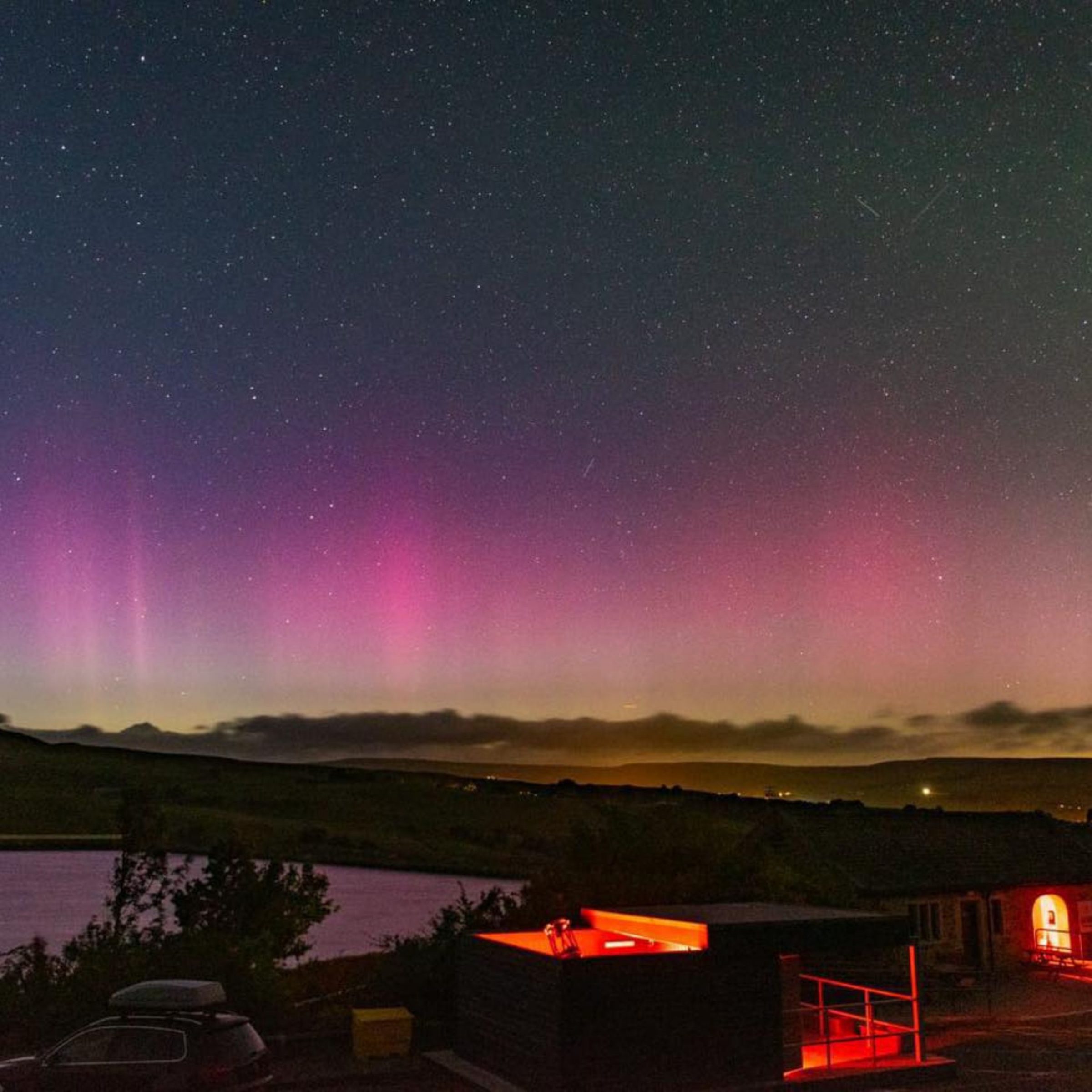 pink and green northern lights over Grassholme Reservoir