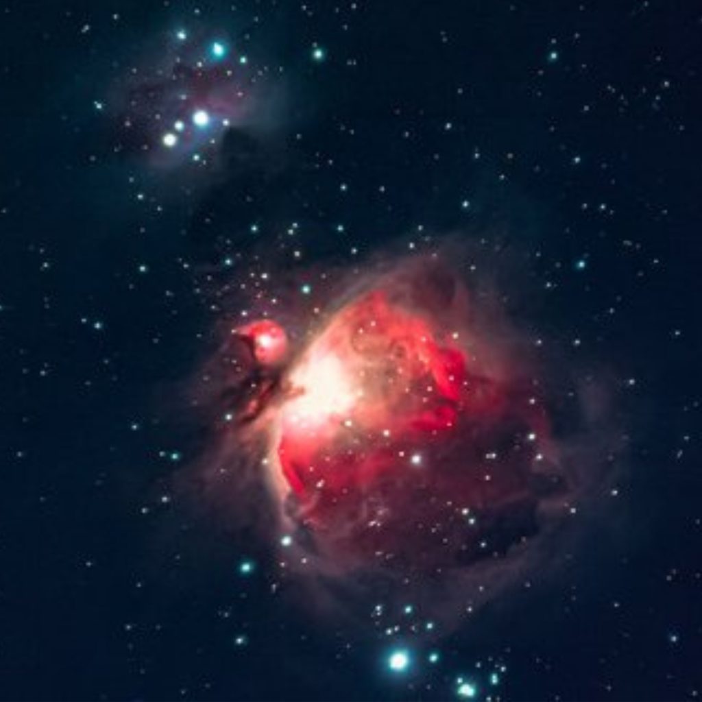 Red galaxy glowing with stars around it