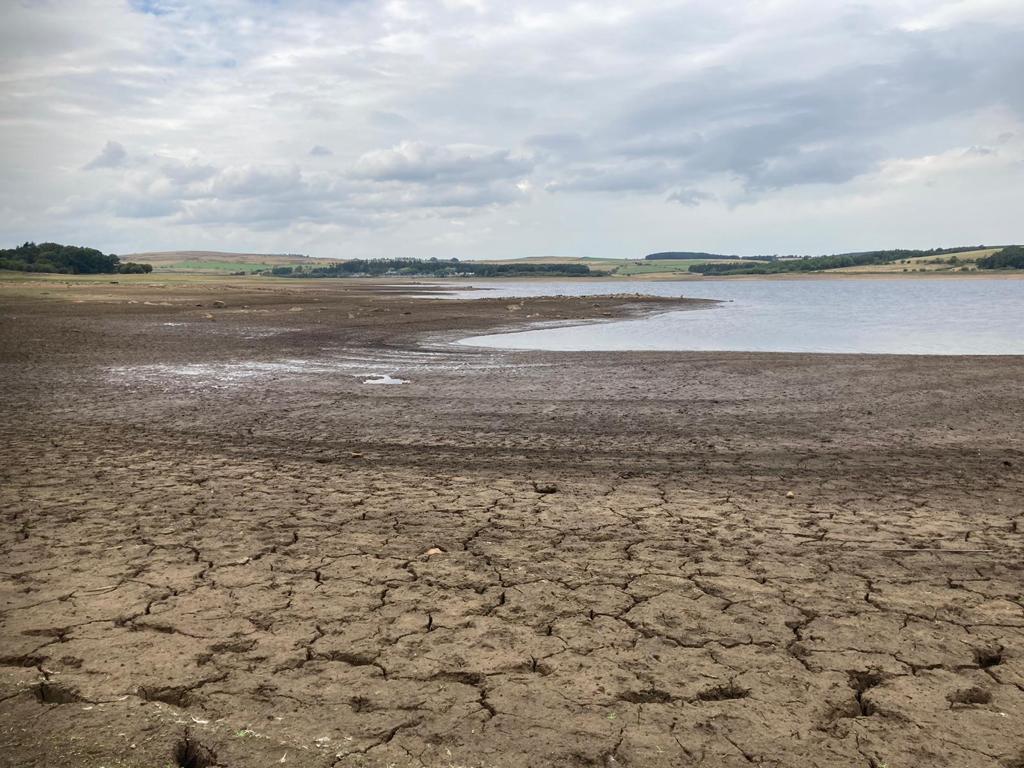 Shot of Derwent Reservoir with very low water levels. The land leading up to the water is sandy, muddy and looks dangerous to walk on