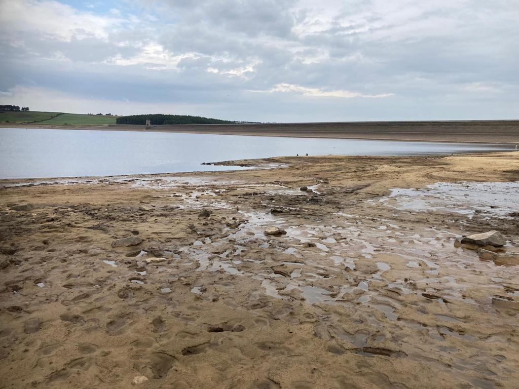 Shot of Derwent Reservoir with very low water levels. The land leading up to the water is sandy, muddy and looks dangerous to walk on