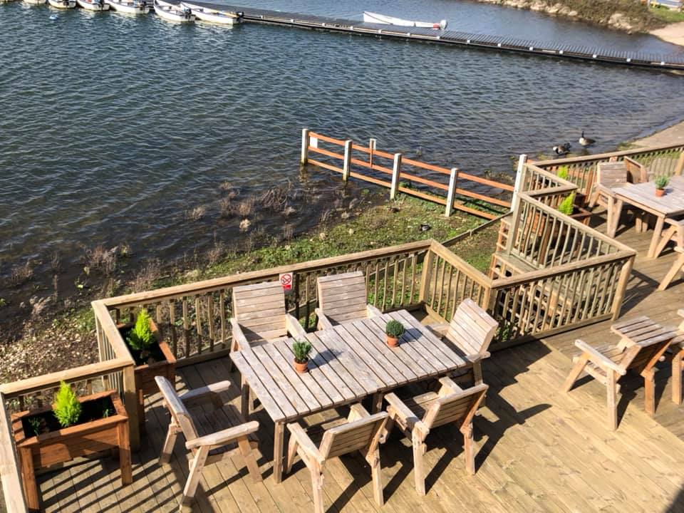 Cafe on the Water at Hanningfield Waterside Park. Image shows the deck with outdoor seating