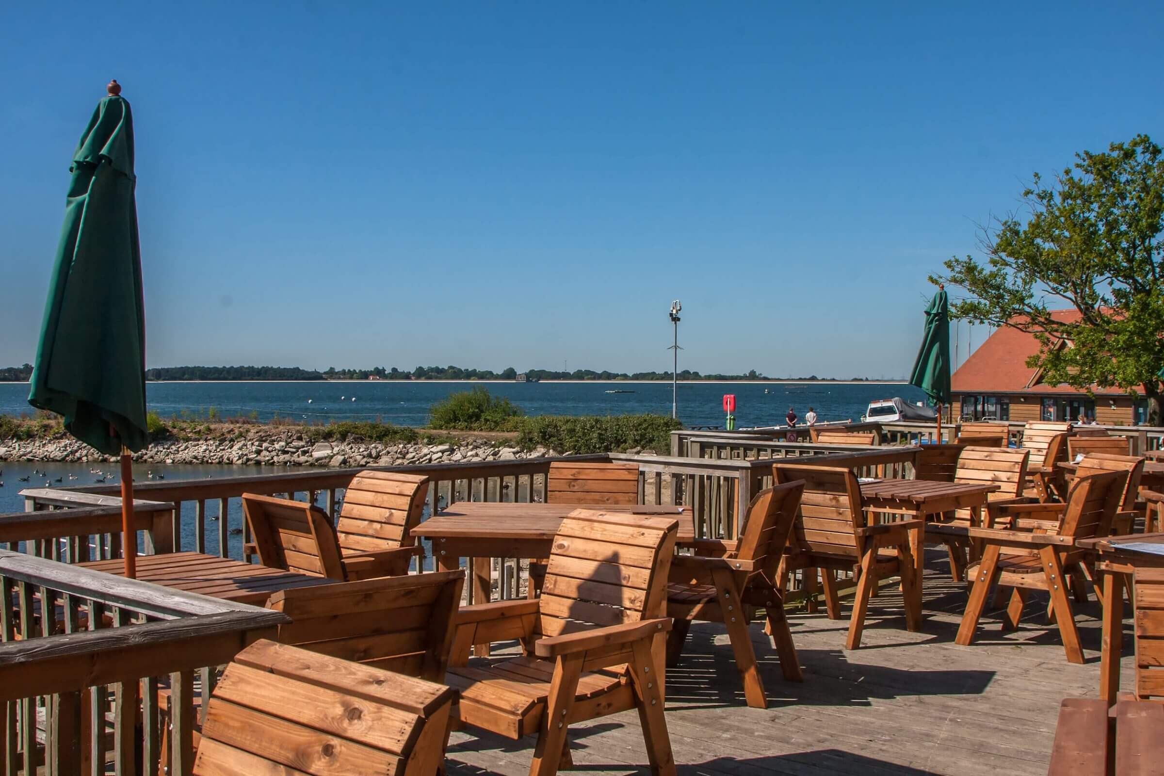Photo of the outdoor seating at the Cafe on the Water. It over looks the reservoir and the clear blue sky above.